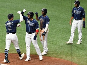 Rays outfielder Hunter Renfroe (11) is greeted by infielder Yandy Diaz (2) after hitting a grand slam in the second inning against the Blue Jays at Tropicana Field in St. Petersburg, Fla., Wednesday, Sept. 30, 2020.