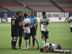 Montreal Impact defender Rudy Camacho (4) receives a red card after punching Vancouver Whitecaps forward Fredy Montero (in the knee during the first half at BC Place.