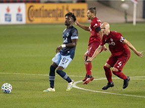 Vancouver Whitecaps forward Tosaint Ricketts battles for a ball with Toronto FC midfielder Michael Bradley during the second half at BMO Field last month. Bradley will miss Saturday's game with a Grade 2 MCL sprain.