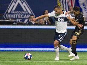 Vancouver Whitecaps  left back Ali Adnan holds off Los Angeles FC forward Josh Perez during a 2019 game.