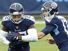 Running back Derrick Henry #22 of the Tennessee Titans takes the hand-off from quarterback Ryan Tannehill #17 and runs with the ball in the first quarter against the Houston Texans at Nissan Stadium on October 18, 2020 in Nashville, Tennessee.