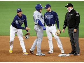ARLINGTON, TEXAS - OCTOBER 24: Max Muncy #13 of the Los Angeles Dodgers argues with umpire Mark Carlson #6 after being tagged out by Willy Adames #1 of the Tampa Bay Rays during the fifth inning in Game Four of the 2020 MLB World Series at Globe Life Field on October 24, 2020 in Arlington, Texas.