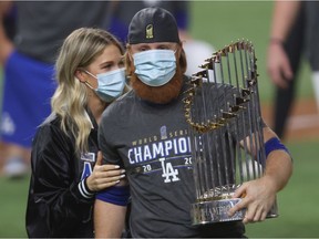 Justin Turner #10 of the Los Angeles Dodgers and his wife Kourtney Pogue, hold the Commissioners Trophy after the teams 3-1 victory against the Tampa Bay Rays in Game Six to win the 2020 MLB World Series at Globe Life Field on October 27, 2020 in Arlington, Texas.