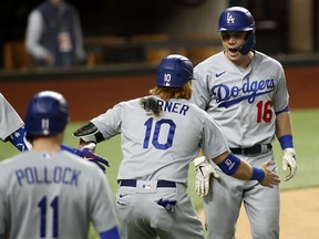 L.A. Dodgers catcher Will Smith celebrates his three-run go-ahead home run with third baseman Justin Turner (10) during the sixth inning against the Atlanta Braves in Game 5 of the NLCS at Globe Life Field.