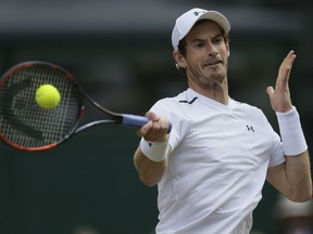 This July 12, 2017 file photo shows Britain's Andy Murray returning to Sam Querrey of the United States during their Men's Singles Quarterfinal Match at the Wimbledon Tennis Championships in London.