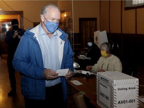 B.C. NDP Leader John Horgan folds his ballot as he votes at Luxton Hall during advance polls for the provincial election in Langford on Monday.