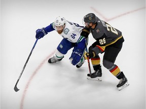 Tyler Motte of Vancouver, left, shown battling with Paul Stastny of the Vegas Golden Knights during the 2020 post-season playoffs in Edmonton, has signed a new two-year deal with the Canucks.