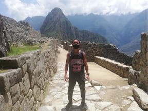 Japanese tourist Jesse Takamaya poses for a photograph during his visit to the ruins of Machu Picchu, Peru, on Oct.10, 2020.