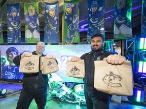 Warehouse supervisor Brody Huizenga, left, and Brendan Hamilton prepare Canucks' food bags for delivery this week to the Salvation Army's Harbour Light location in the Downtown Eastside.