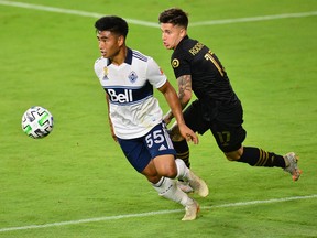 Vancouver Whitecaps midfielder Michael Baldisimo, left, battling with LAFC midfielder Brian Rodriguez last month, has been one of the bright spots for the MLS team this year. But he never would have gotten a chance if it hadn't have been for the COVID-19 pandemic throwing the team into disarray.
