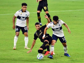 Vancouver Whitecaps forward Fredy Montero tussles with LAFC defender Mohamed El-Munir during last month's game at Banc of California Stadium.