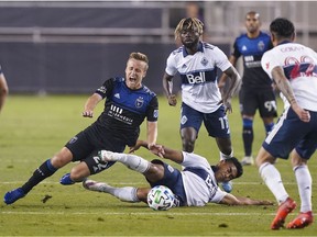 Vancouver Whitecaps midfielder Michael Baldisimo (centre, bottom) fouls San Jose Earthquakes forward Tommy Thompson (left) during the second half at Earthquakes Stadium.