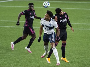Vancouver Whitecaps forward Theo Bair controls a header against Seattle Sounders' defender Xavier Arreaga, right, during MLS action on Tuesday at Providence Park in Portland.