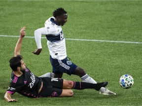 Seattle Sounders midfielder Nicolas Lodeiro (10) slide tackles Vancouver Whitecaps midfielder Janio Bikel (19) during the first half at Providence Park.