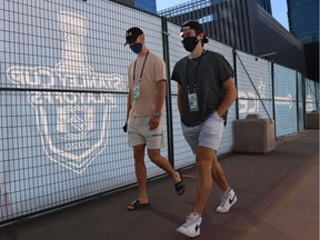 Elias Pettersson (left) and Quinn Hughes of the Vancouver Canucks walk around Rogers Place in Edmonton.