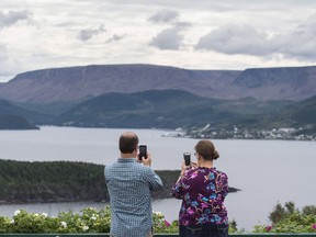 Tourists take pictures with their mobile phones of the Gulf of St. Lawrence in Gros Morne National Park, Newfoundland and Labrador, on Monday, August 15, 2016.