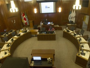 Practically empty council chambers at Vancouver City Hall during a council meeting on Nov. 3. Only three city staffers occupied seats as councillors participated via Zoom, with the large screen above the mayor's desk broadcasting relevant materials for councillors.