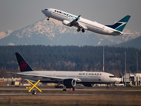 An Air Canada flight departing for Toronto, bottom, taxis to a runway as a Westjet flight bound for Palm Springs takes off at Vancouver International Airport, in Richmond, B.C., on Friday, March 20, 2020.