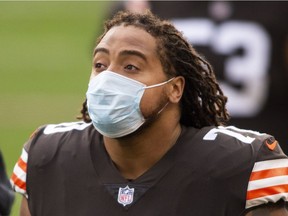 Cleveland Browns tackle Kendall Lamm wears a mask on the sidelines.