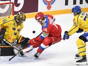 Russia's Vasili Podkolzin takes a shot on Sweden's goaltender Samuel Ersson (L) as Jacob Nilsson (R) defends at the Karjala Cup on Saturday.
