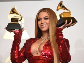 In this file photo singer Beyonce poses with her Grammy trophies in the press room during the 59th Annual Grammy music Awards on February 12, 2017, in Los Angeles, California.