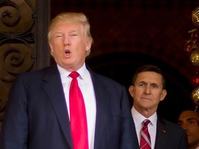 In this file photo taken on December 21, 2016 US President-elect Donald Trump (L) stands with Trump National Security Adviser designate Lt. General Michael Flynn (R) at Mar-a-Lago in Palm Beach, Florida.