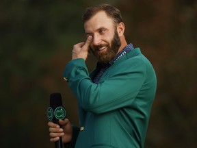 Dustin Johnson wipes away a tear while addressing the crowd after donning the green jacket as the 2020 Masters golf champion on Nov. 15, 2020 at Augusta National Golf Club in Augusta, Ga.