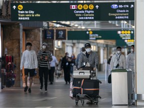 Airline passengers wearing face masks make their way around Vancouver International Airport in Richmond, BC, August, 5, 2020.