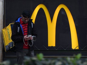 A delivery service employee waits for an order outside a McDonald's in Barcelona. Fast food is proving to be a pandemic-resilient business.