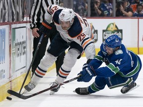 Quinn Hughes of the Vancouver Canucks, right, will get to see a lot of Leon Draisaitl and the Edmonton Oilers this season in the all-Canadian North Division, which begins play on Jan. 13.
