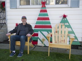 Retired carpenter Bill Day sits in one of the Adirondack chairs he made in his home shop as part of an Empty Stocking Fund fundraiser at Rogers Sugar.