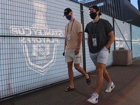 Elias Pettersson (left) and Quinn Hughes of the Vancouver Canucks walk at Rogers Place on July 29, 2020 in Edmonton. Players from Europe and the U.S. will have to quarantine in Vancouver for 14 days before training camp opens on Jan. 3.