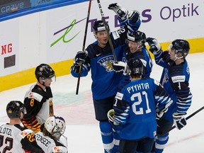 Henri Nikkanen (28), Aku Raty (34), Ville Heinola (4) and Mikael Pyyhtia (21) of Finland celebrate Raty's goal against Germany during the 2021 IIHF world junior championships at Rogers Place on Dec. 25, 2020.