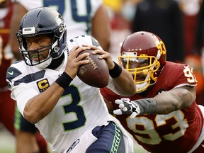 Quarterback Russell Wilson of the Seattle Seahawks eludes the tackle of defensive tackle Jonathan Allen of the Washington Football Team during their National Football League game at FedExField in Landover, Md., on Dec. 20, 2020.
