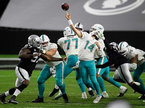 Arden Key of the Las Vegas Raiders is penalized for a face mask against Ryan Fitzpatrick (14) of the Miami Dolphins during the fourth quarter of a game at Allegiant Stadium on Dec. 26, 2020, in Las Vegas, Nevada.