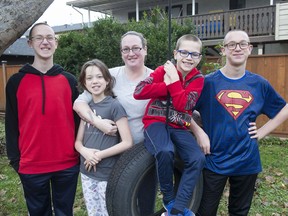 Tina Pellerdi (centre) and her children (from left) Jonathan (13), Carmela (11), Marcuis (8) and Manning (also 13) in the backyard of their Abbotsford home.