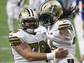 Erik McCoy, left, and Alvin Kamara of the New Orleans Saints celebrate following a touchdown by Kamara during the first quarter against the Minnesota Vikings at Mercedes-Benz Superdome on Dec. 25, 2020 in New Orleans, La.