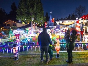 A young family checks out the bling of the holiday season at 8222 Burnlake Dr. in Burnaby.