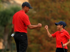 Tiger Woods and son Charlie fist bump on the 18th hole during the final round of the PNC Championship at the Ritz Carlton Golf Club on December 20, 2020 in Orlando, Florida.