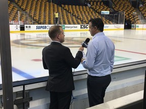 Sports broadcasters like Sportsnet 650’s Brendan Batchelor (left, interviewing Canucks head coach Travis Green rinkside at TD Garden in Boston) typically travel with the team around the continent.