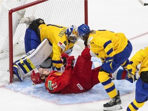 Russia's Vasili Podkolzin (19) crashes into Sweden goalie Jesper Wallstedt (1) as Philip Broberg (5) defends during first period IIHF World Junior Hockey Championship action in Edmonton on Wednesday, December 30, 2020.
