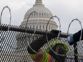 Work crews install razor wire on top of the fencing that now surrounds the U.S. Capitol on Jan. 15, 2021 in Washington, D.C., ahead of the inauguration of President-elect Joe Biden on Jan. 20.
