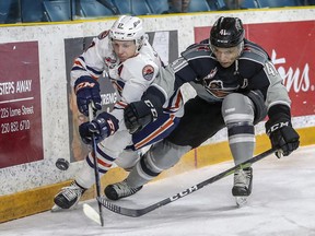 Kryell Sopotyk of the Kamloops Blazers, left, battles along the boards for puck possession with Alex Kannok Leipert of the Vancouver Giants during a WHL game in Kamloops in April 2019.