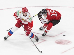 Russia's Vasili Podkolzin (left) and Austria's Luis Lindner battle for the puck in the third period of IIHF World Junior Hockey Championship action in Edmonton on Dec. 29, 2020.