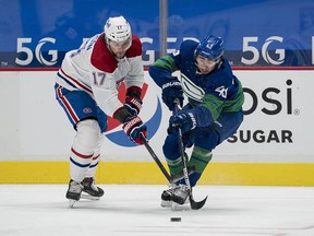 Canadiens forward Josh Anderson, left, checks Vancouver Canucks defenceman Quinn Hughes at Rogers Arena.