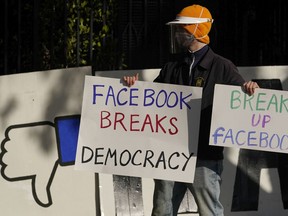 A demonstrator joins others outside of the home of Facebook CEO Mark Zuckerberg In November 2020 to protest what they say is Facebook spreading disinformation.