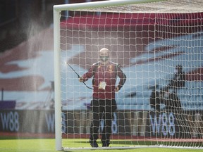 The goal posts are cleaned before a June 2020 closed-doors Premier League match at Villa Park in Birmingham between host Aston Villa and Chelsea.