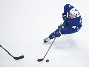 Nils Hoglander of the Vancouver Canucks skates with the puck during the NHL team's training camp at Rogers Arena in Vancouver.