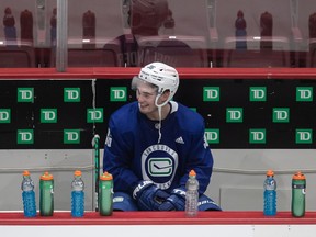 Vancouver Canucks' Nils Hoglander, of Sweden, sits on the bench during the NHL hockey team's training camp in Vancouver, on Monday, January 11, 2021.