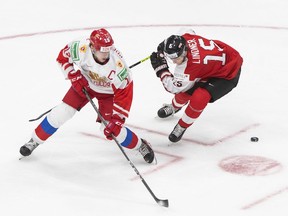 Russia's Vasili Podkolzin (19) and Austria's Luis Lindner (15) battle for the puck during third period IIHF World Junior Hockey Championship action in Edmonton on Tuesday, December 29, 2020.